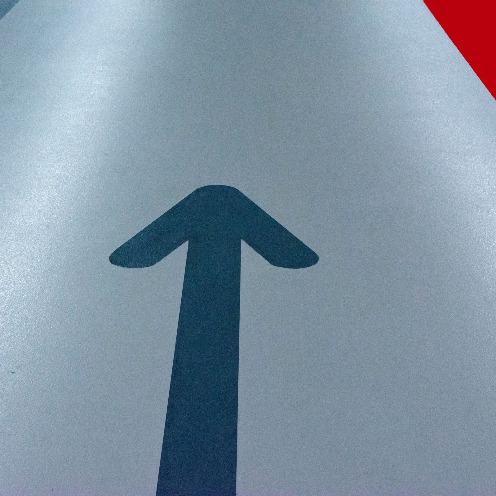 Coated parking deck floor with directional arrow and red lane marking