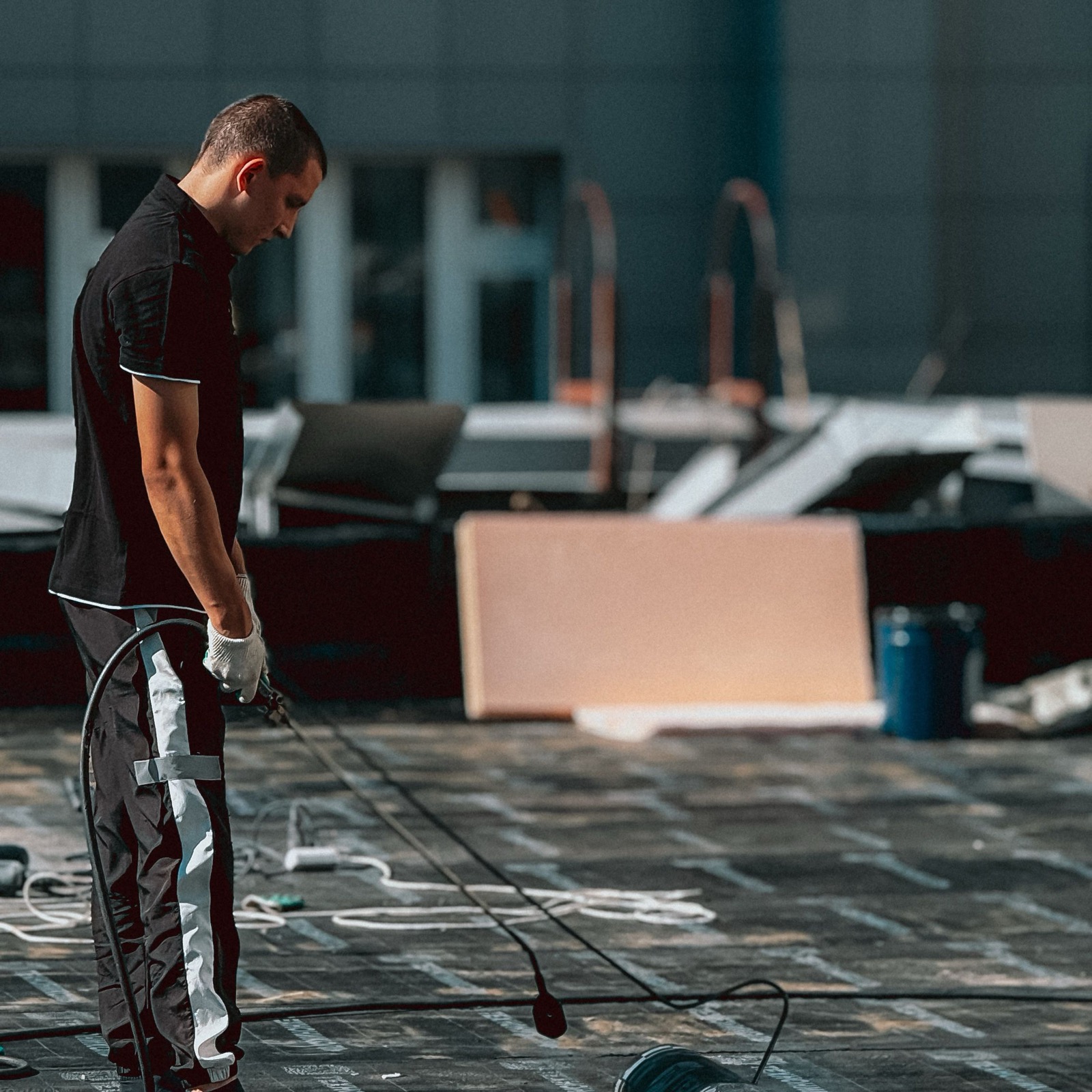 Worker applying waterproofing on a flat roof deck